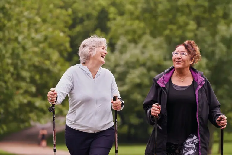 Two older adults walking with nordic sticks