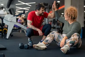 Personal trainer high fiving a client in a gym